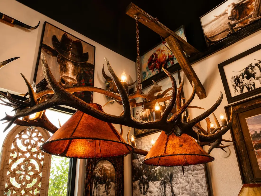 Rustic antler chandelier in Weatherford TX with rawhide shades and western art