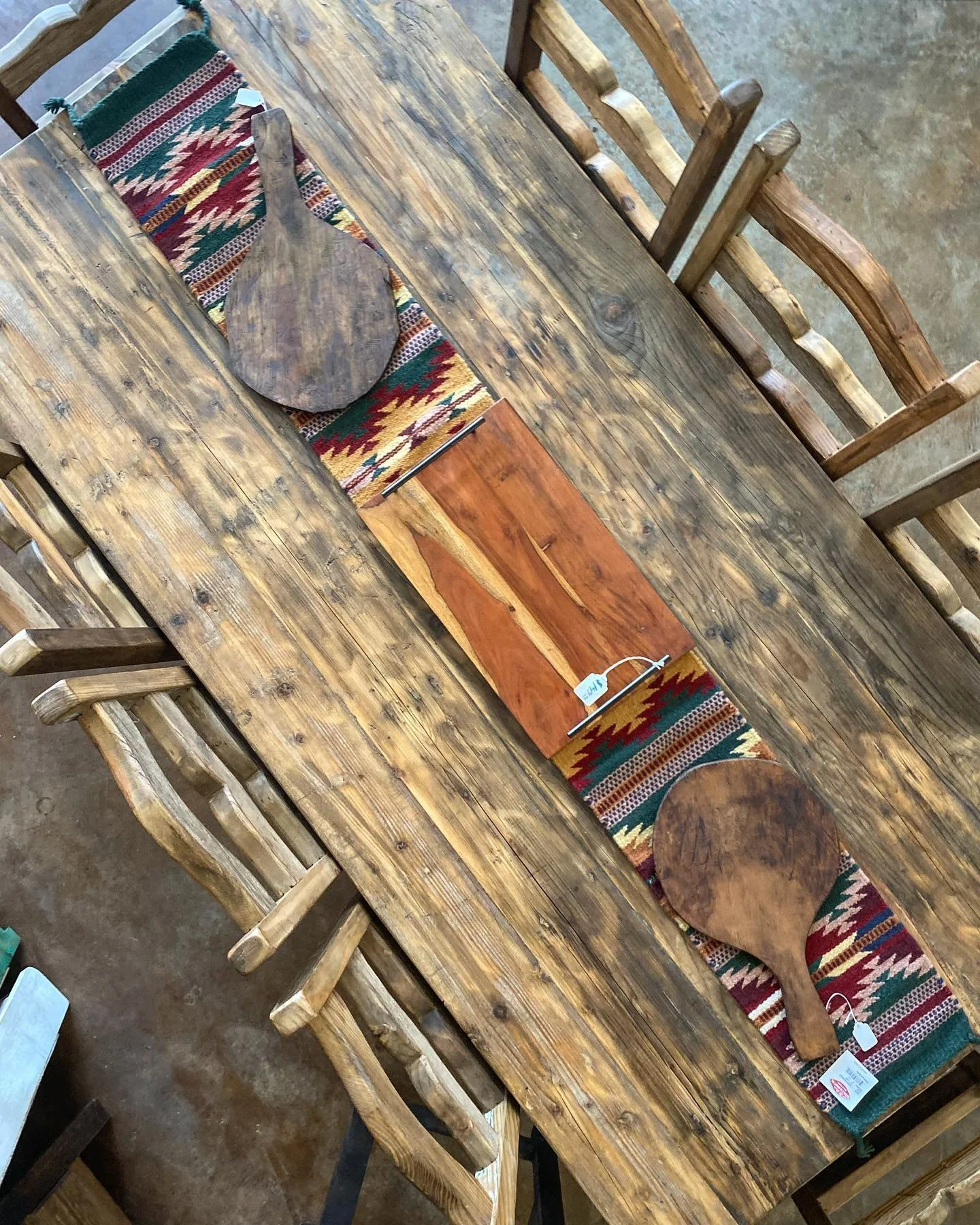 Reclaimed wood dining table with southwestern runner and rustic log chairs