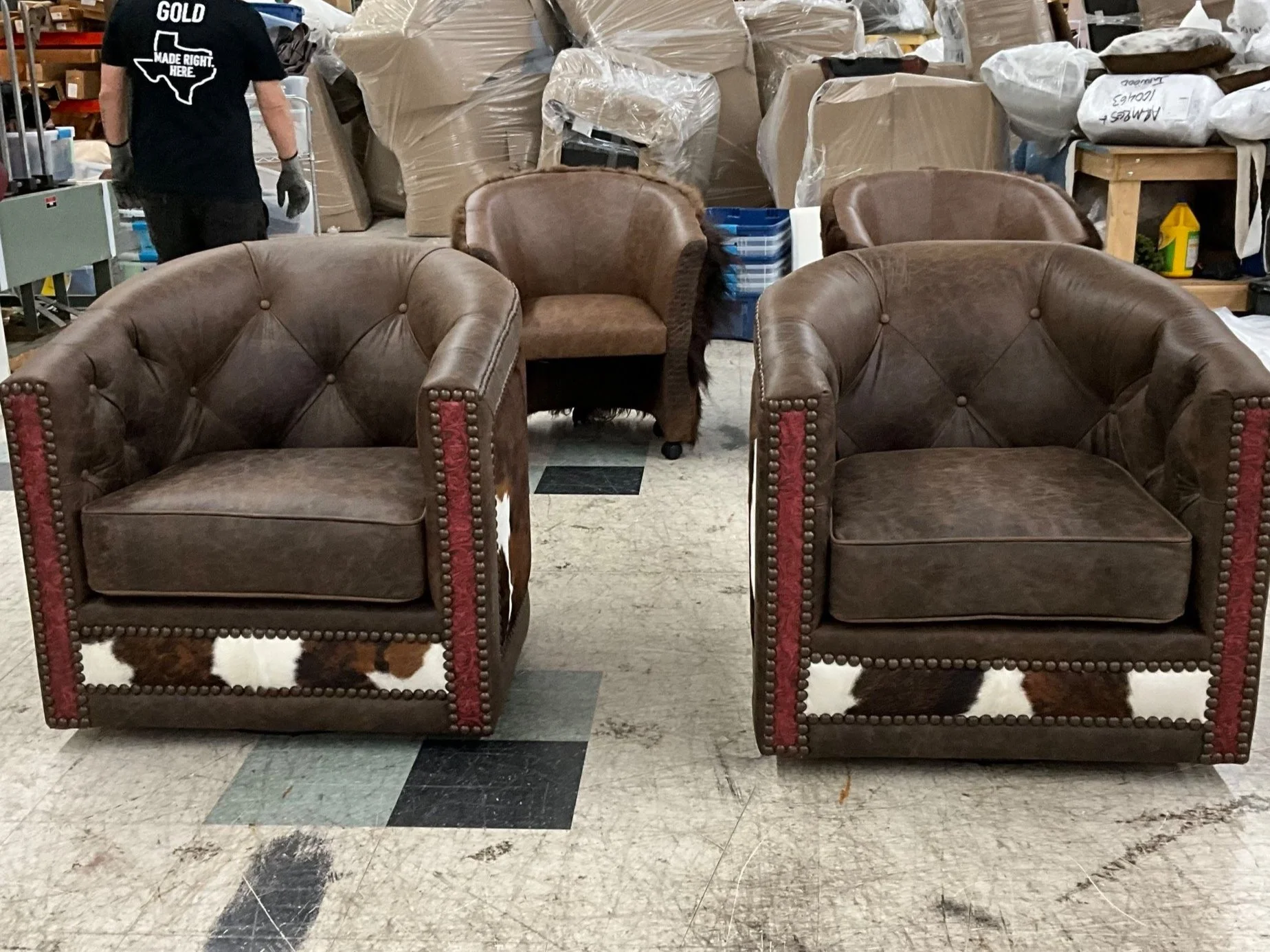 Tufted leather swivel barrel chairs with cowhide back panels