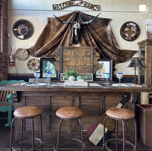Rustic ranch home bar with longhorn skull and cowhide backdrop