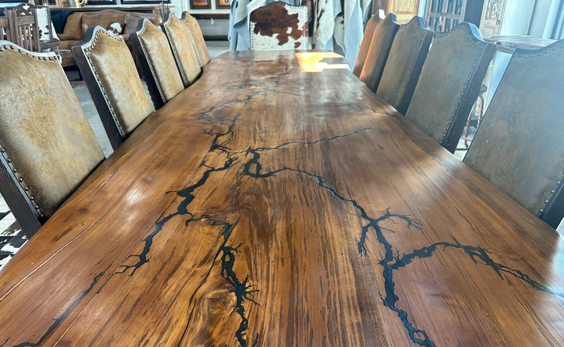 Fractal Lichtenberg-burned mesquite dining table with cowhide chairs