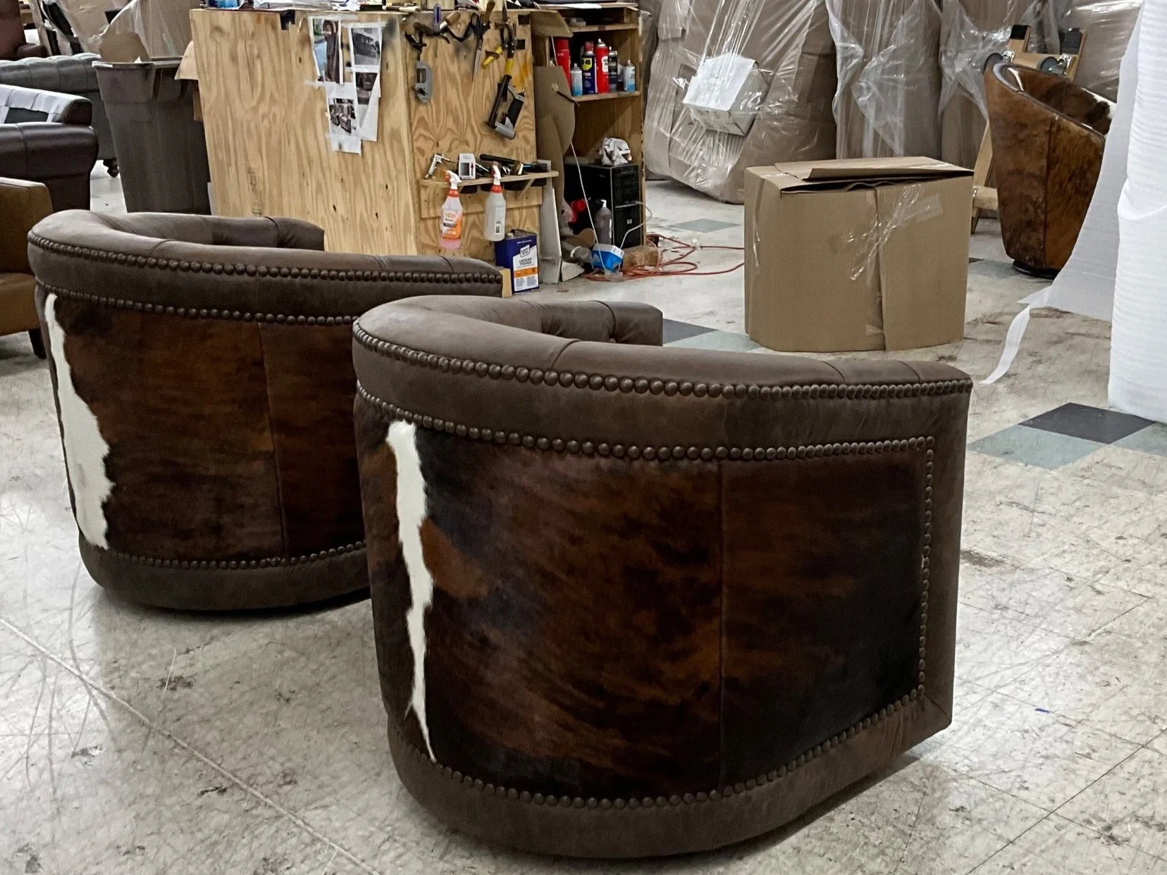 Back view of cowhide leather swivel barrel chairs with nailhead trim
